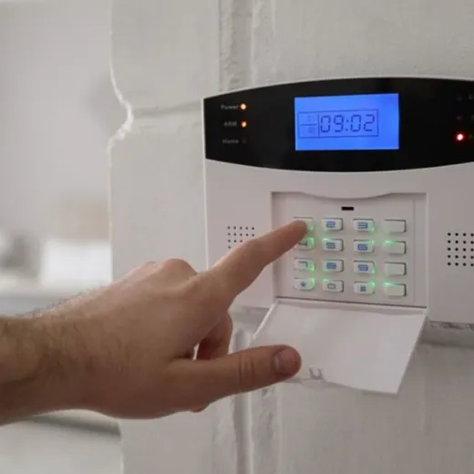 An alarm keypad and control panel mounted on a wall